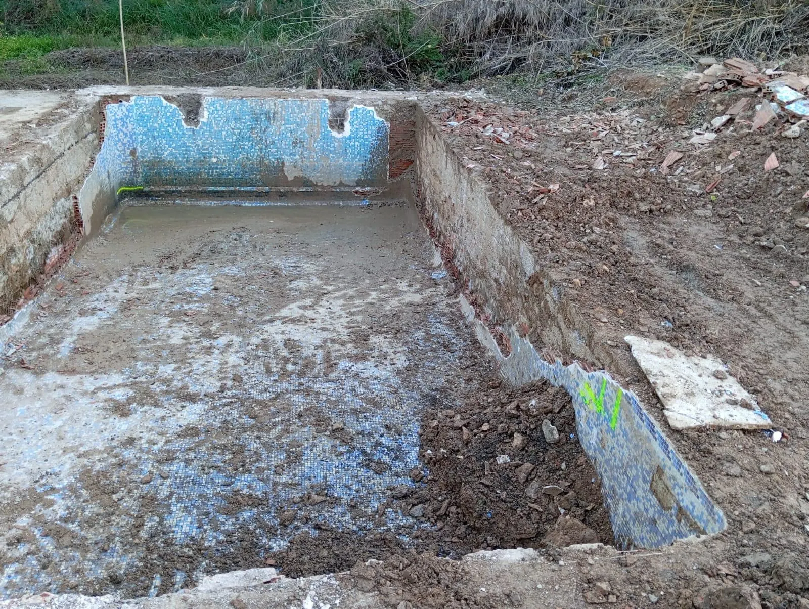 Piscina exterior antigua con gresite azul despegado antes de la reforma en Vilamarxant