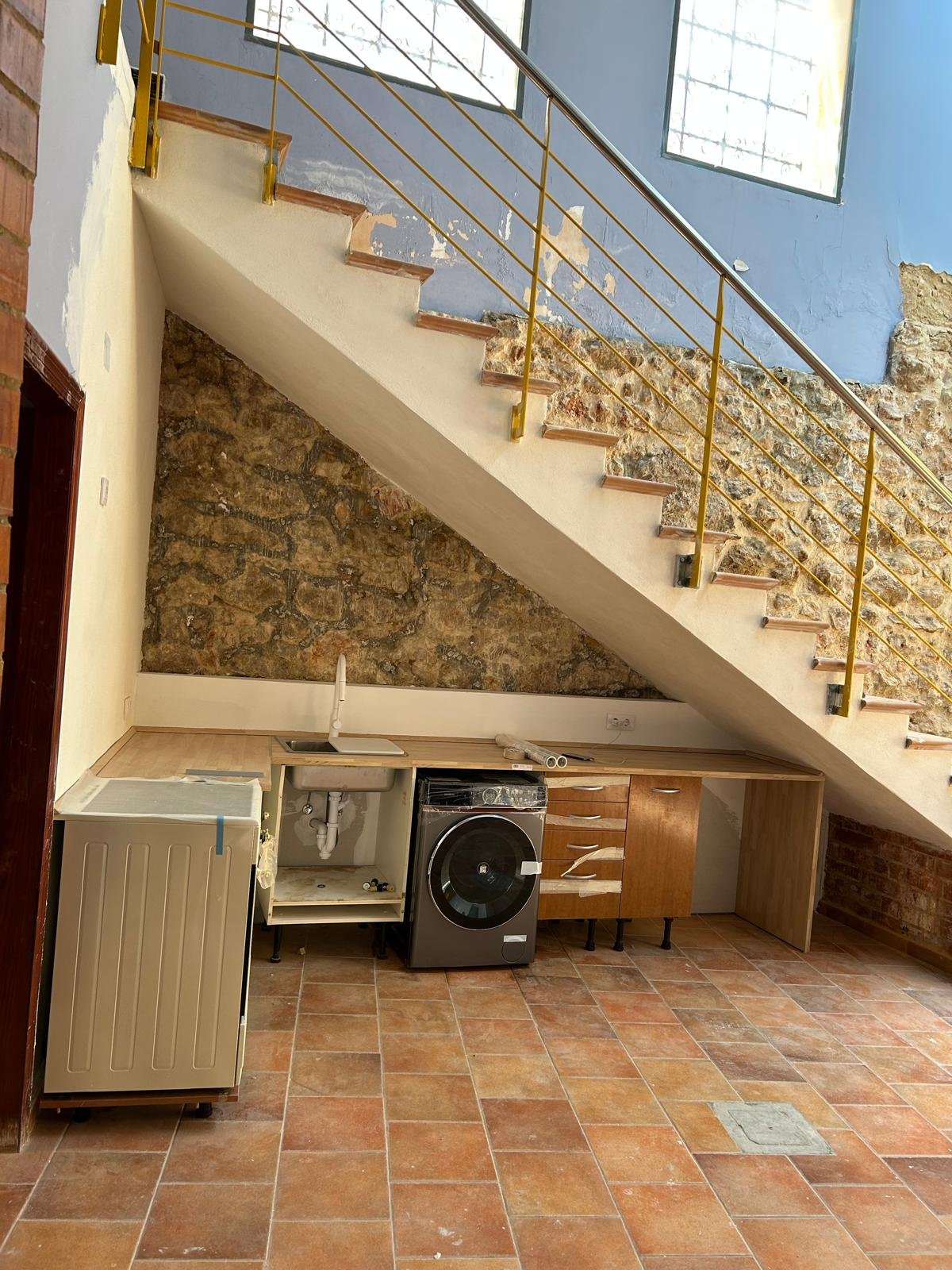 Cocina básica funcional construida bajo la escalera para la cédula de habitabilidad en Llíria