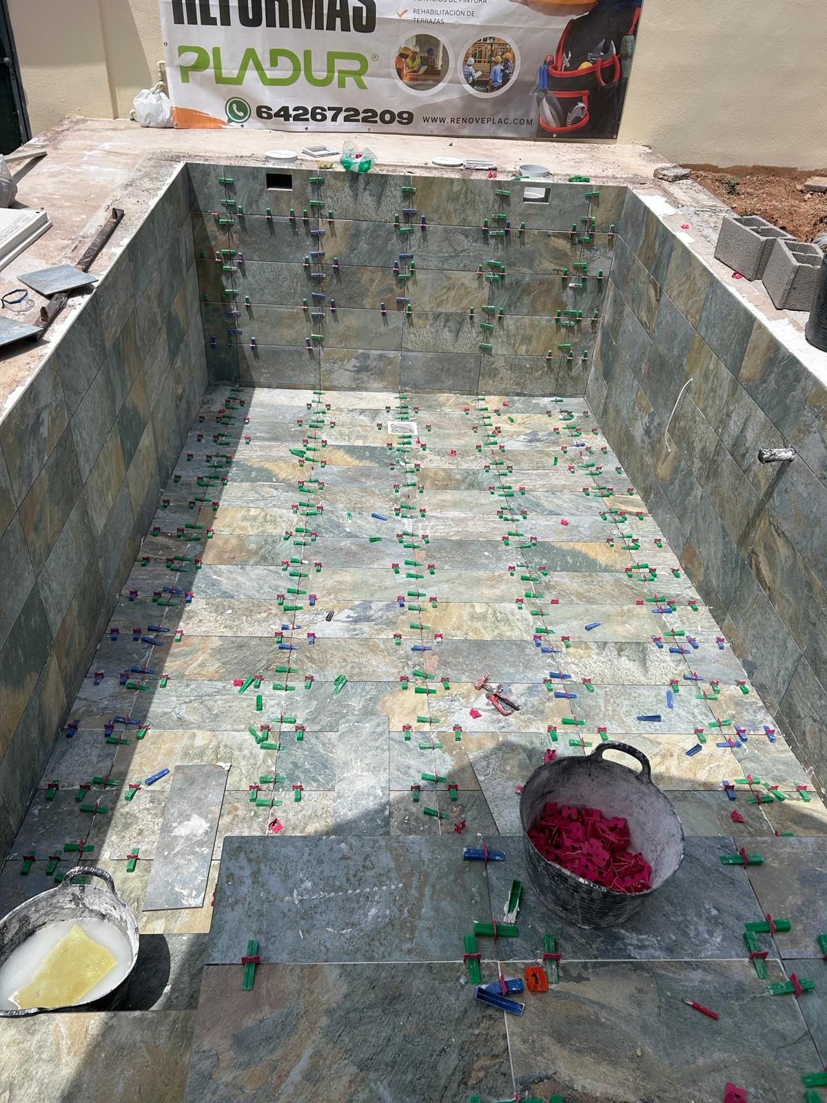 Piscina alicatada con porcelánico efecto piedra en La Pobla de Vallbona