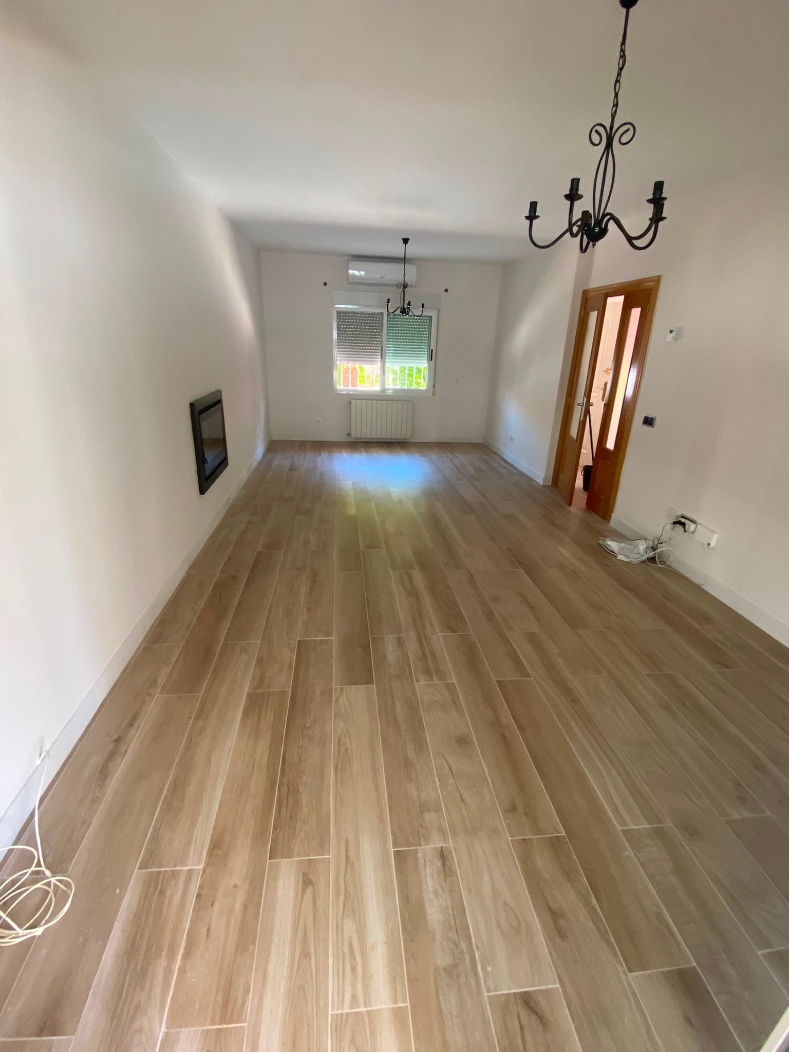 Salón con pavimento porcelánico efecto madera instalado por Renoveplac en La Pobla de Vallbona