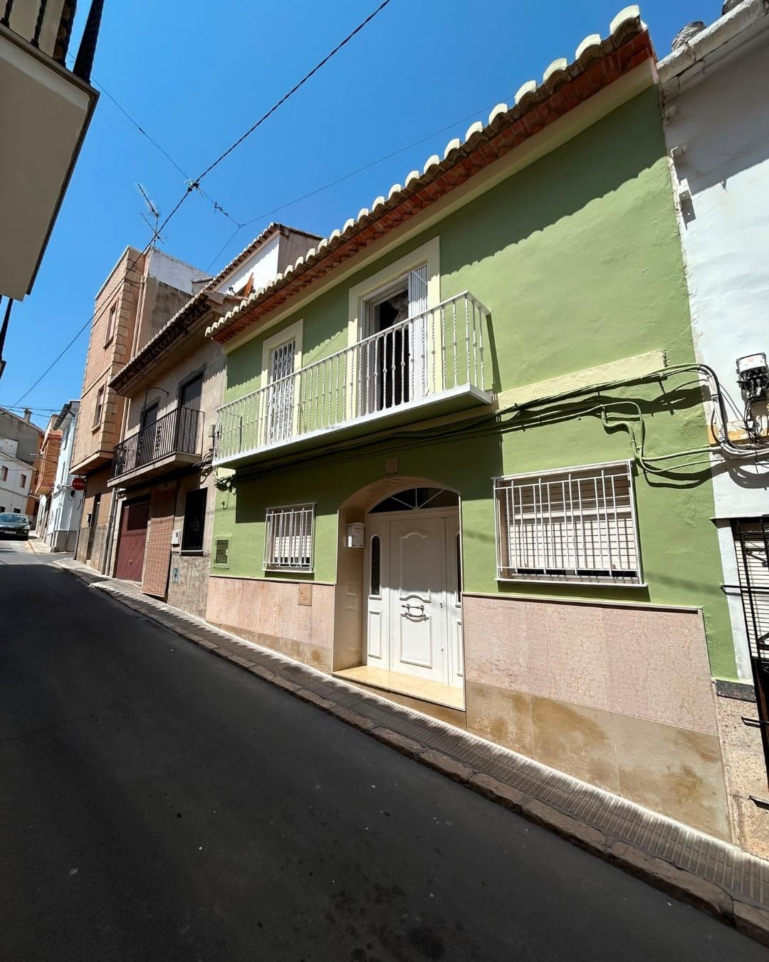 Fachada de vivienda en el casco antiguo de Llíria recién pintada, acabado uniforme en verde
