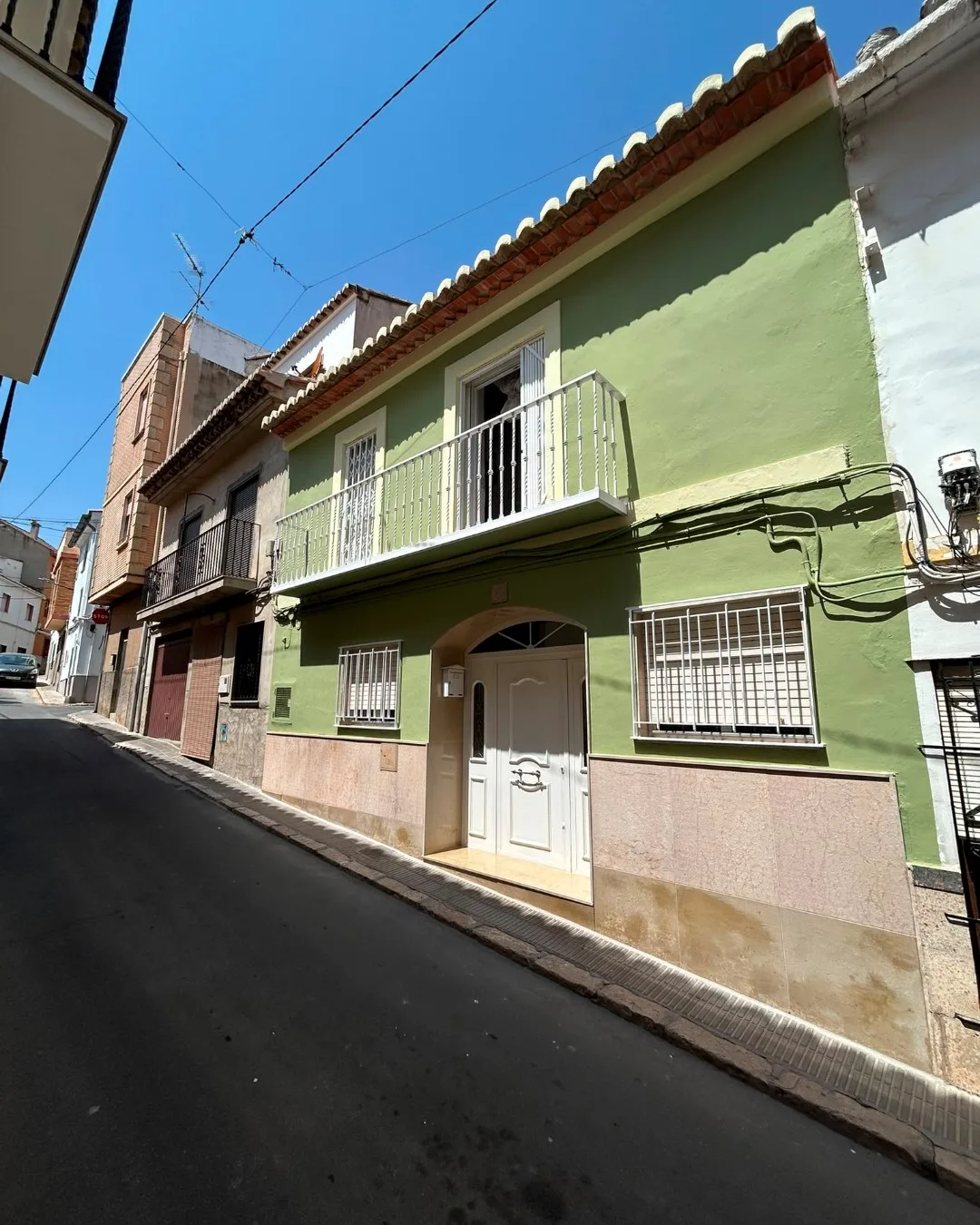 Fachada de vivienda en el casco antiguo de Llíria recién pintada, acabado uniforme en verde