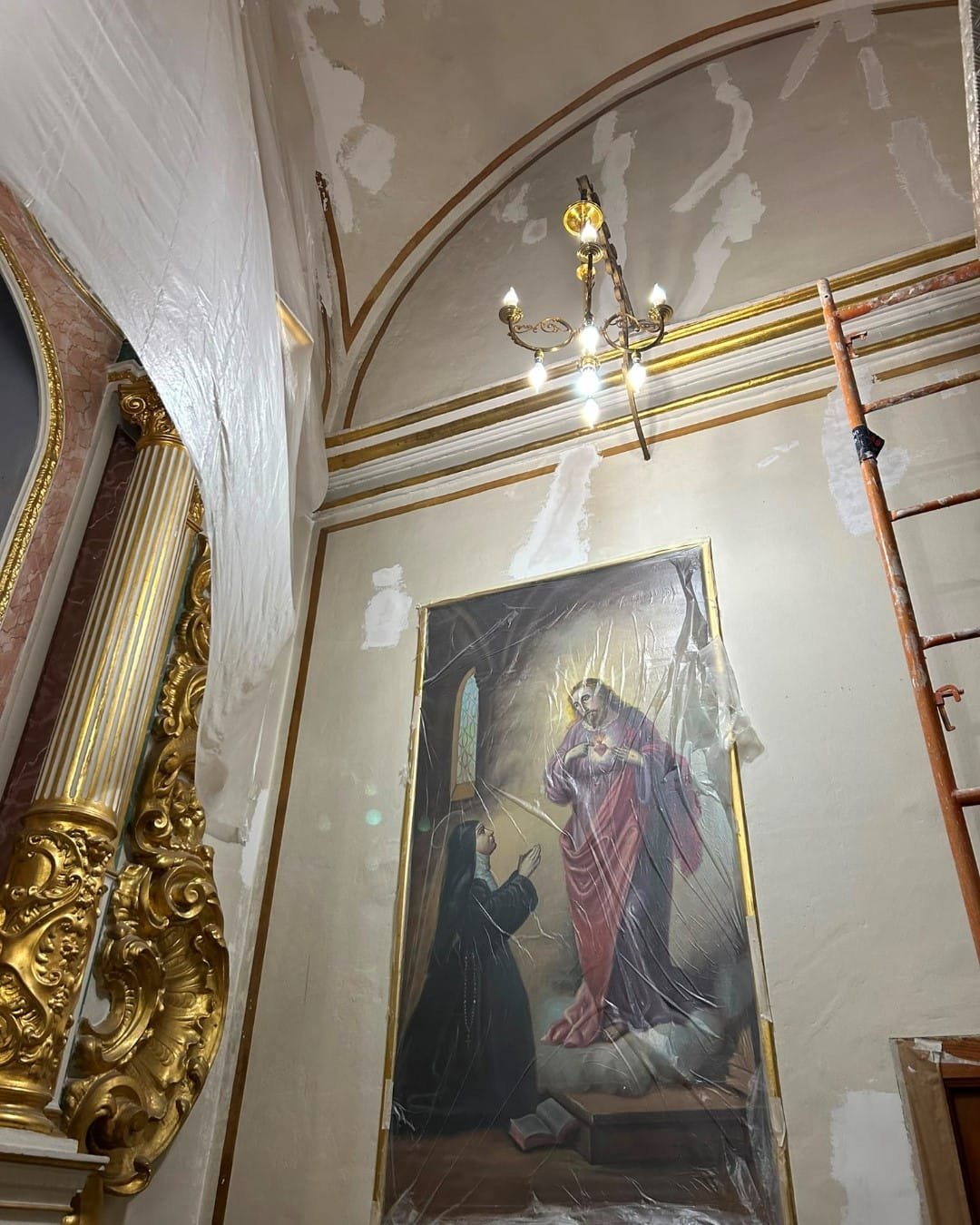 Lienzo original protegido con plástico y pared sin repasar antes de restaurar la capilla de la Iglesia del Remei en Llíria