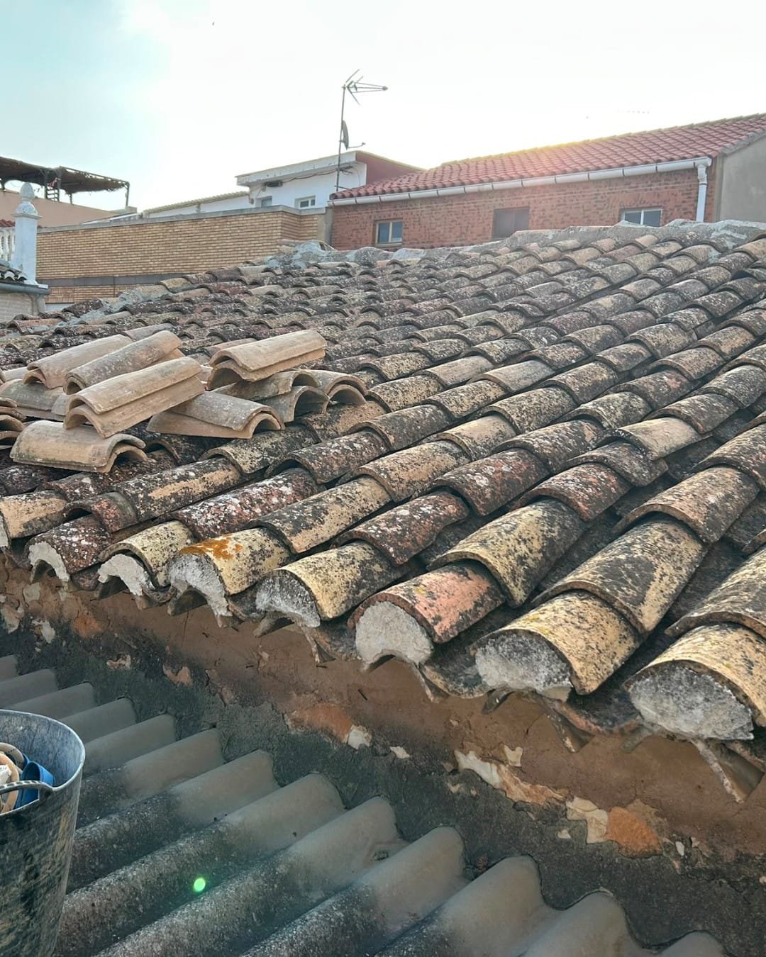 Tejado de teja árabe envejecido con tejas sueltas antes de la reparación en Vilamarxant