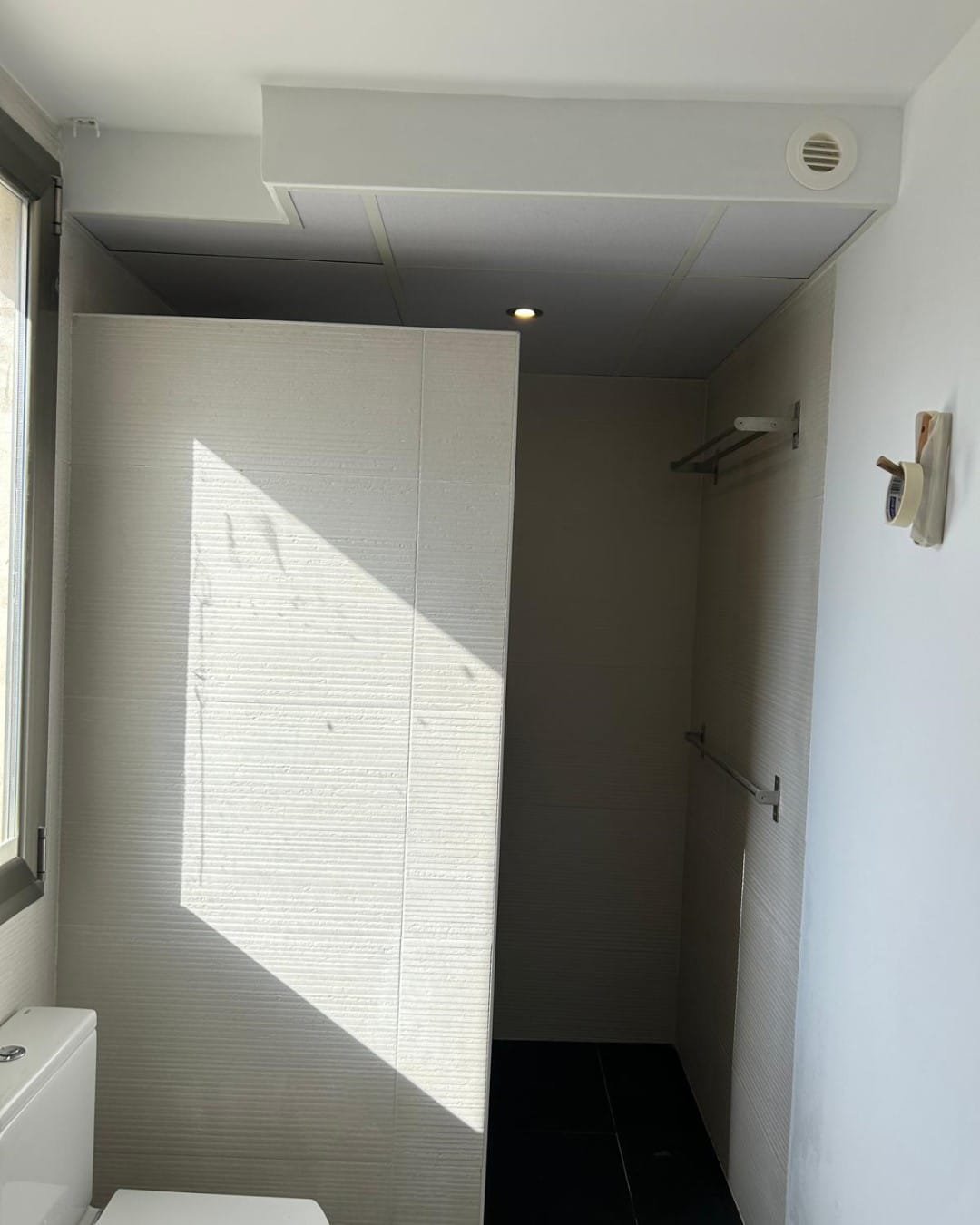 Techo desmontable terminado en un baño de Bétera, con rejilla de ventilación